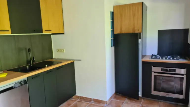 Montage de kitchenette IKEA avec meubles en chêne et frigo noir