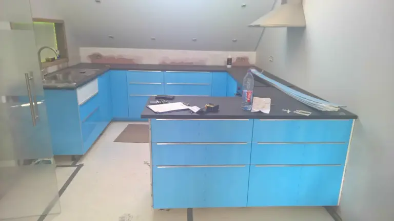 Montage de cuisine IKEA bleue : meubles bas et îlot en cours de pose