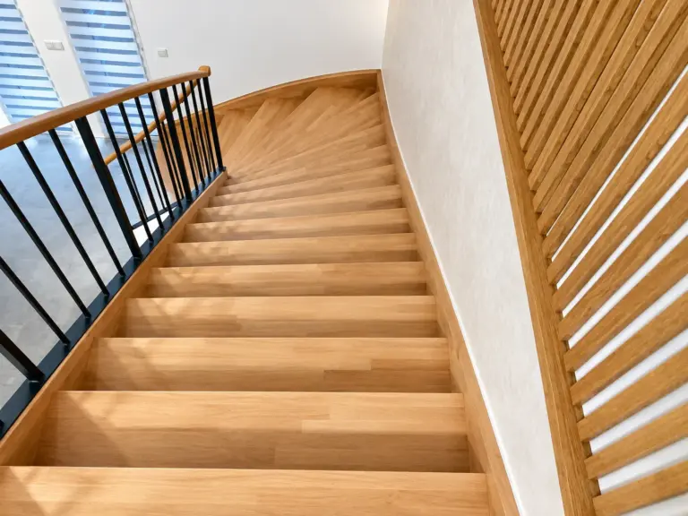 Escalier tournant habillé en chêne avec garde-corps métallique et claustra en bois